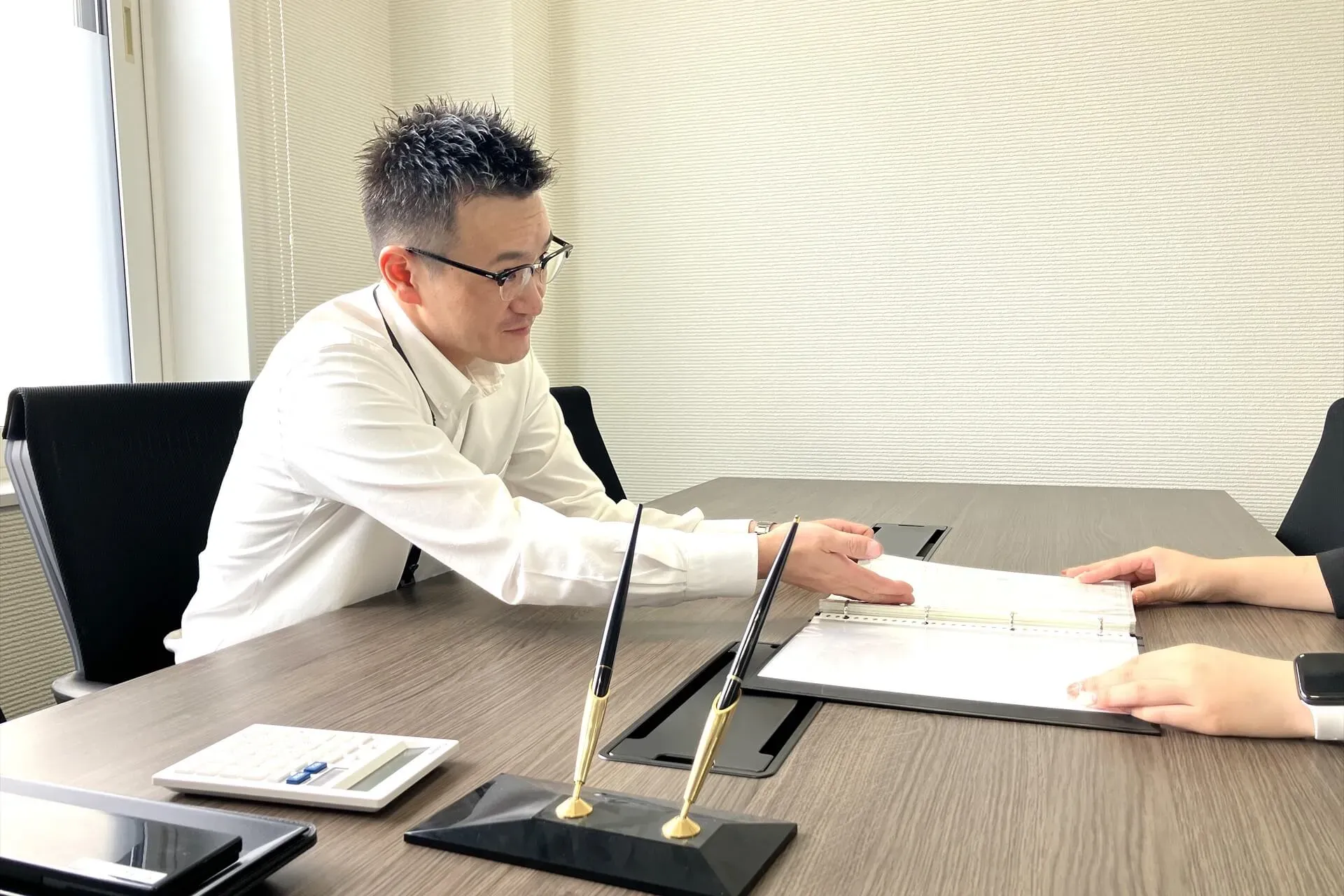 資料を使って不動産売買の相談に対応するセクトのスタッフ